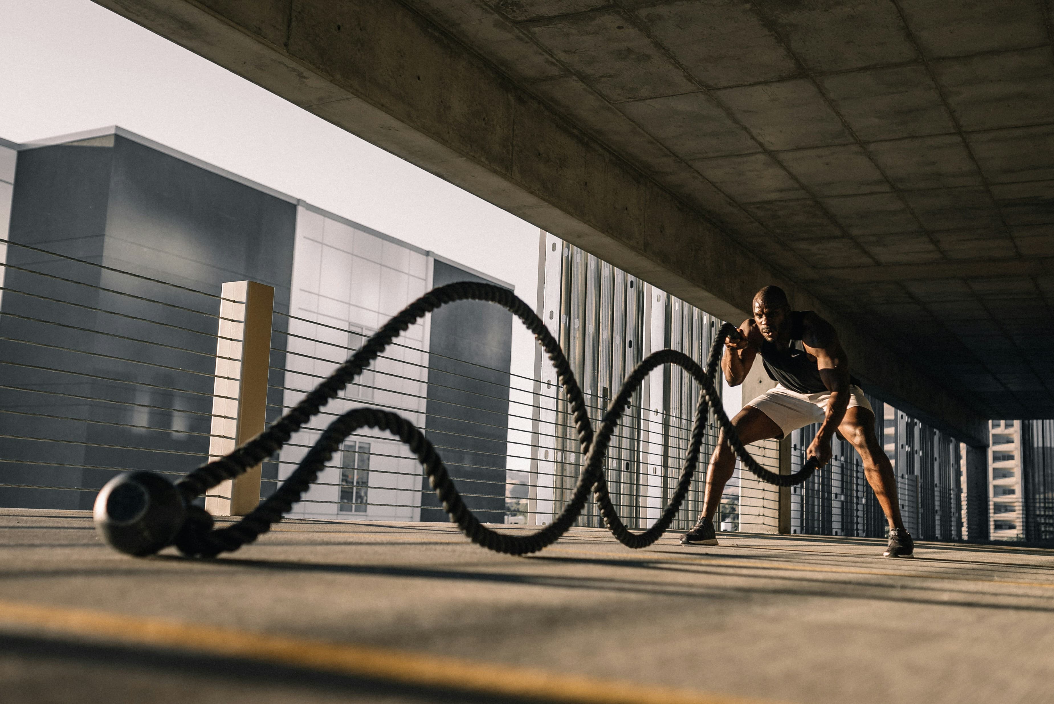 Athlete using battle ropes in an urban training space.